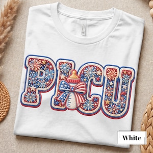 May include: White t-shirt with a patriotic design. The word "PICU" is embroidered in red, white, and blue with a baby bottle in the center. The design includes fireworks and stars.