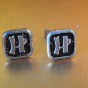 Mod vintage 60s &quot;washed&quot; gold tone metal cuff links with a black enamel and letter H.