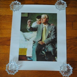 May include: A vintage print of a Norman Rockwell painting showing a man in a suit comforting a young boy in a hospital bed. The man is holding a thermometer in his hand and the boy is looking at the thermometer.
