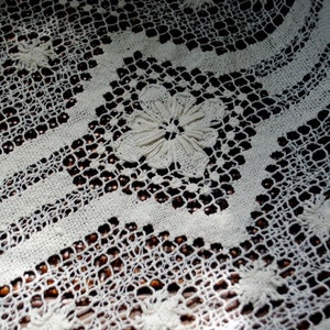 K&ouml;nnte beinhalten: Wei&szlig;e geh&auml;kelte Spitzentischdecke mit einem zarten Blumenmuster. Die Spitze ist filigran und detailliert, mit einer feinen Webart. Die Tischdecke ist perfekt, um jeder Tischdekoration einen Hauch von Eleganz zu verleihen.