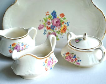 Vintage 1930s porcelain set of the  four: tray, sugar bowl, creamer, gravy dish with delicate pastel color  flowers  pattern.