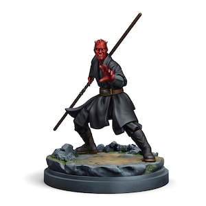May include: A detailed figurine of Darth Maul from Star Wars. The figure is posed with a double-bladed lightsaber, wearing a black robe and boots. The character has red skin, horns, and is standing on a rocky base.