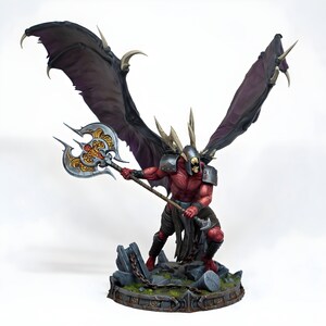 May include: A detailed figurine of a demonic warrior with large, dark purple wings and a menacing expression. The figure is holding a large, ornate axe. The warrior is posed on a rocky base with a chain, showcasing intricate details and a fantasy theme.