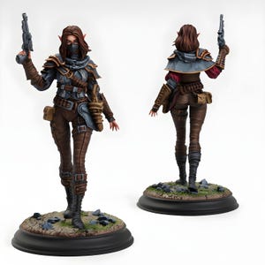 Puede incluir: Figura detallada de un personaje femenino de fantasía, posando con una pistola. Viste un atuendo blindado azul y marrón, una máscara facial y botas marrones. La figura se alza sobre una base con rocas y hierba, mostrando detalles intrincados.