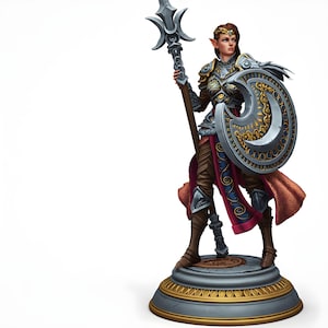 May include: A detailed figurine of a female warrior, clad in ornate armor and holding a spear and shield. The shield features a crescent moon design. The figure stands on a decorative base with gold accents, set against a white background.