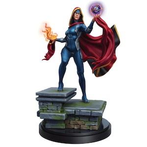 May include: A figurine of a female character in a blue bodysuit and red cape, holding a ball of purple energy and a flame. The figure stands on a stone platform with a black base. The character has a hood and mask.