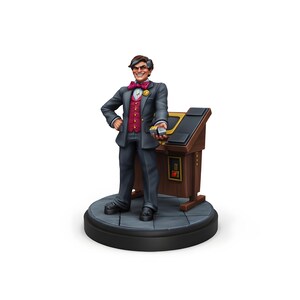 Puede incluir: Figura de un hombre con traje gris, chaleco rojo y pajarita, sosteniendo cartas. Se encuentra junto a un podio de madera sobre una base redonda gris. La figura tiene una expresión sonriente.