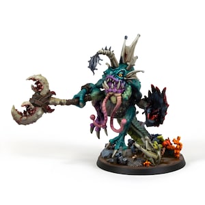 Puede incluir: Figura en miniatura detallada de una criatura de fantasía con cuerpo verde y azul verdoso, boca morada y un arma. La figura tiene una expresión amenazante y está posada sobre una base redonda. La figura sostiene un arma con un diseño de garra.