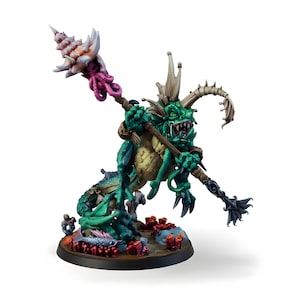 Puede incluir: Figura en miniatura detallada de una criatura marina con cuerpo verde y amarillo, sosteniendo un bastón rematado con una concha y tentáculos. La figura tiene dientes afilados y está sobre una base con coral y peces.