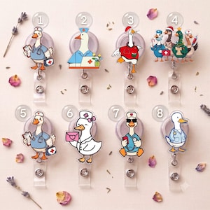 May include: Eight acrylic badge reels featuring cartoon ducks dressed as medical professionals. Designs include ducks with stethoscopes, clipboards, medical kits, and holiday-themed outfits, each labeled with a numbered circle from one to eight.