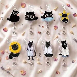 Puede incluir: Ocho portatarjetas retráctiles con ilustraciones de gatos negros. Los diseños incluyen un gato con una flor, una cabeza de gato, un gato con un pez, un gato en una estrella, un gato con un collar de girasol y tres gatos con batas blancas de laboratorio.