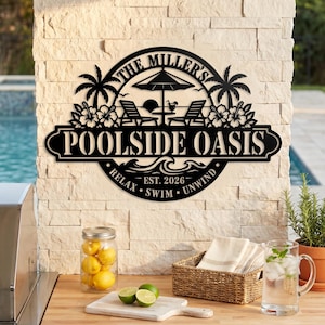 May include: A black circular metal sign featuring the text THE MILLER'S POOLSIDE OASIS, EST. 2026, RELAX, SWIM, UNWIND. The design includes silhouettes of palm trees, two lounge chairs, a beach umbrella, a drink, hibiscus flowers, and ocean waves.