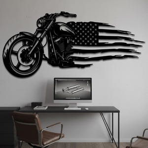 May include: Black metal motorcycle wall art with an American flag design. The motorcycle is depicted in profile, with the flag appearing to stream behind it. The artwork is mounted on a white wall, above a black desk and chair.