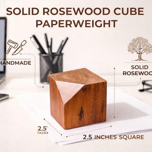 May include: A handmade solid rosewood cube paperweight, 2.5 inches square. The cube has a geometric design with a lighter wood accent on one side. The text on the image reads "Solid Rosewood Cube Paperweight".