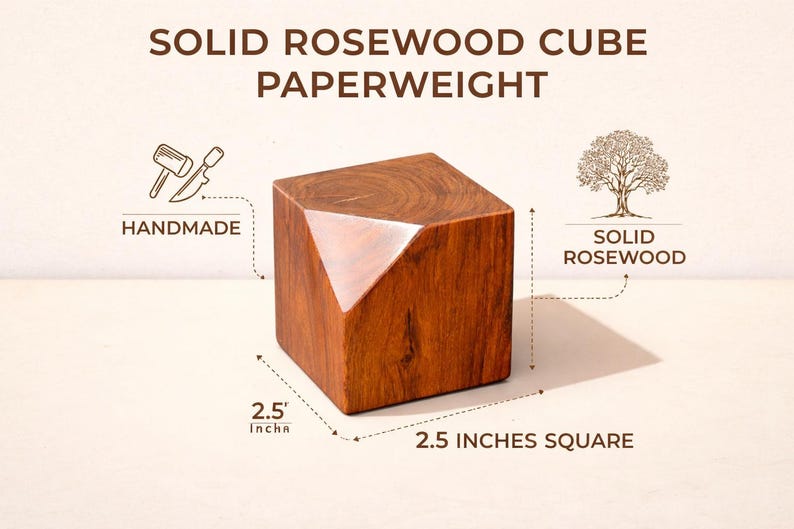 May include: Solid rosewood cube paperweight, handmade from solid rosewood. The cube is 2.5 inches square with a faceted design on one corner. The wood has a rich, warm brown color.