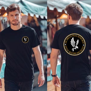 May include: Black t-shirt with a gold and black emblem on the front and back. The front emblem has a bird design. The back of the shirt has the text "LOS ANGELES POLICE DEPARTMENT SPECIAL WEAPONS AND TACTICS".