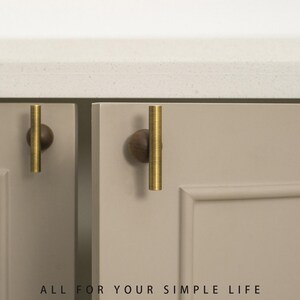 May include: Close-up of cabinet doors with brass-colored bar pulls and dark wood ball knobs. The doors are a light gray color, and the countertop is white. The text "ALL FOR YOUR SIMPLE LIFE" is at the bottom.