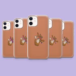 Puede incluir: Cinco fundas para teléfono con una ilustración de un gato marrón con una bandera arcoíris. El gato está sobre un fondo color melocotón. Las fundas son para un smartphone.