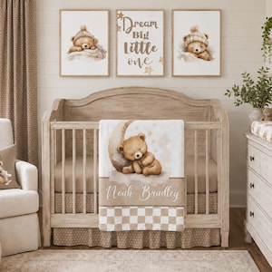 May include: A nursery interior with a crib, rocking chair, and dresser in neutral colours. The crib has a teddy bear-themed blanket and bedding. Three framed prints above the crib show a teddy bear. A pillow on the chair also has a teddy bear design.