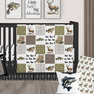May include: A patchwork baby quilt featuring alternating squares with illustrations of deer, fish, ducks, and tackle boxes, alongside arrow and geometric patterns in olive green, brown, and white. A gray pillow with a white deer head and the text MASON JAMES.