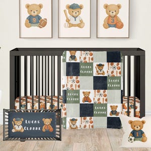 May include: A nursery set with a dark cot, bedding, and wall art. The set includes a quilt, cot sheet, and bumper with a teddy bear and sports theme. Three framed prints depict teddy bears with sports equipment. A pillow with a teddy bear holding a football is also included.
