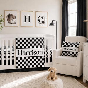 May include: A white crib featuring a black and white checkered blanket with the name Harrison printed in the center. The nursery includes a matching checkered pillow on a white armchair, three framed wall prints, and a plush dog toy on a pouf.
