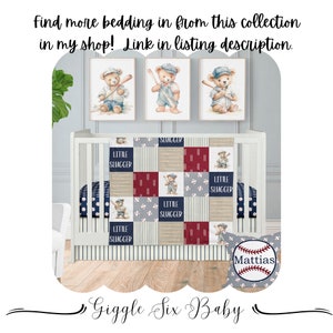 Op de afbeelding: Een wit babybedje met een blauw en rood baseball-thema deken. De deken heeft een patchwork-ontwerp met baseballs, strepen en de woorden "Little Slugger". Boven het babybedje hangen drie ingelijste foto's met illustraties van beren die honkbal spelen. Het babybedje staat op een houten vloer. De tekst "Giggle Six Baby" staat onderaan de afbeelding.