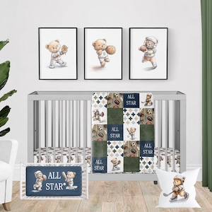 May include: A nursery set featuring a gray crib with a sports-themed bedding set, including a blanket, bumper, and pillow. The set includes framed artwork of teddy bears playing sports. The text "ALL STAR" is visible on the bumper and blanket.