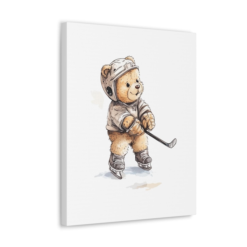 May include: A brown teddy bear wearing a white hockey helmet and jersey, holding a hockey stick. The bear is standing on a white background.