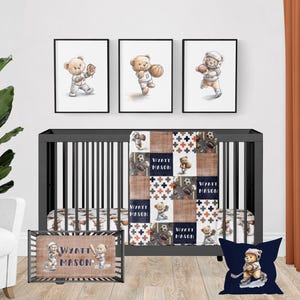 May include: A baby crib with a brown and white patchwork quilt featuring a bear playing different sports. The quilt has the name "Wyatt Mason" repeated on it. The crib also has a brown and white changing pad with the same name and a blue pillow with a bear playing hockey.