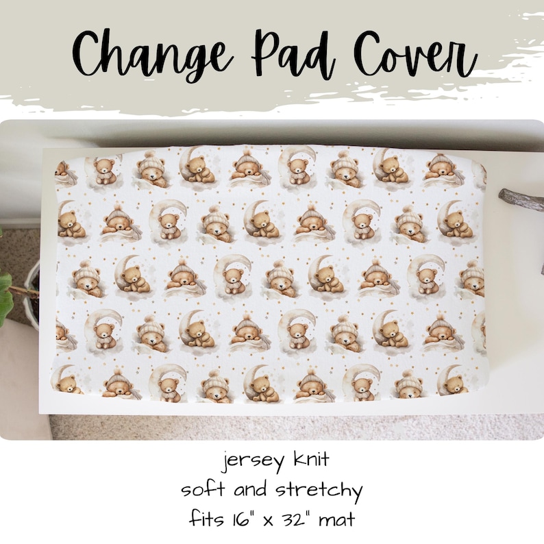 May include: A white change pad cover featuring a pattern of sleeping teddy bears on crescent moons. The text "Change Pad Cover" is at the top. The cover is jersey knit and fits a 40.6cm x 81.3cm mat.