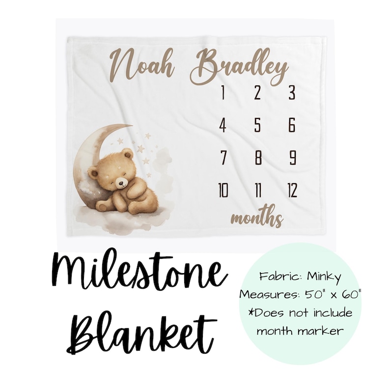 May include: White milestone blanket with the name "Noah Bradley" in brown script. Features a teddy bear on a crescent moon, numbers 1-12, and the word "months". Measures 127cm x 152cm.