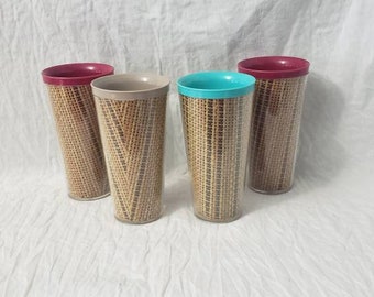 May include: Four tall drinking glasses with a woven pattern. The glasses have different colored rims: two are burgundy, one is turquoise, and one is beige.