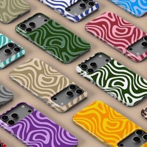 Pode incluir: Uma coleção de capas para smartphones com um padrão ondulado e abstrato. As capas vêm em várias cores, incluindo verde, castanho, roxo e laranja. O design apresenta um padrão de redemoinho orgânico repetido na parte de trás das capas.