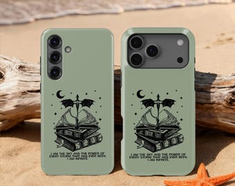Op de afbeelding: Twee saliegroene telefoonhoesjes met een zwart grafisch ontwerp met een draak, boeken en een halve maan. De tekst op de hoesjes luidt: "IK BEN DE LUCHT EN DE KRACHT VAN ELKE STORM DIE OOIT IS GEWEEST. IK BEN ONEINDIG."