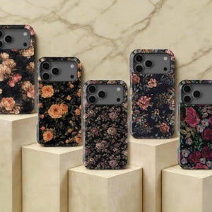 May include: Five rectangular smartphone cases featuring dark backgrounds with various floral patterns. Each case displays a distinct arrangement of roses and other blossoms in shades of pink, orange, red, and cream, with a grey camera cutout area.
