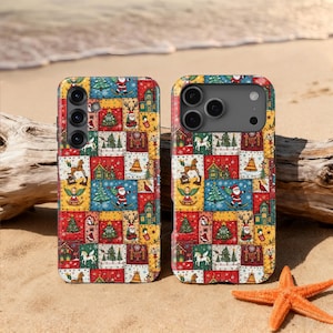 May include: Two colorful phone cases with a patchwork design featuring Christmas-themed illustrations. The cases display Santa Claus, Christmas trees, angels, and reindeer. The cases are resting on a sandy beach with a starfish.