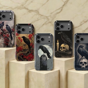 May include: Five rectangular smartphone cases featuring dark, gothic-inspired illustrations. Designs include black ravens perched on red roses, tree branches, a tombstone against a full moon, a skull with a lit candle, and a skull on a pedestal.