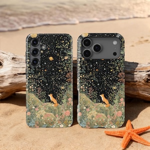 Pode incluir: Duas capas de telemóvel com um design fantasioso com um céu noturno estrelado, uma raposa e elementos florais. As capas são pretas com uma ilustração detalhada. O fundo inclui um cenário de praia com areia, madeira flutuante e uma estrela do mar.