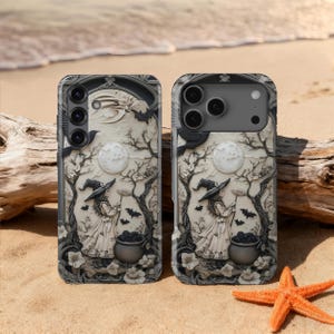 May include: Two phone cases with a Halloween theme. The cases feature a witch with a cauldron, bats, and a full moon. The design is in black and white with a 3D effect. The cases are on a sandy beach with a starfish and driftwood.