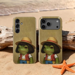May include: Two phone cases with a whimsical illustration of a frog wearing a straw hat, red vest, and blue jeans. The frog has dark hair and large eyes. The cases are tan and set on a sandy beach with a starfish and driftwood.