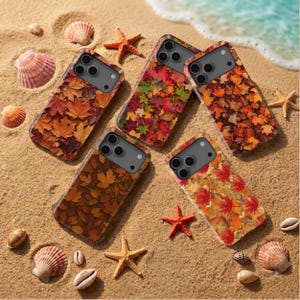 May include: Five rectangular smartphone cases featuring various autumn leaf patterns in shades of orange, red, yellow, and brown. Each case has a dark gray camera cutout area with three circular lenses, arranged on a sandy surface with seashells and starfish.