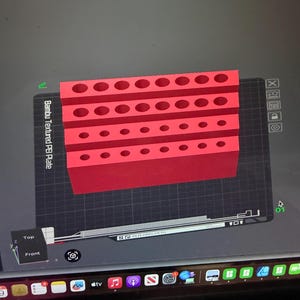 May include: A red, rectangular tool holder with multiple circular openings of varying sizes. The tool holder is displayed on a computer screen with the text "Bambu Textured PEI Plate". The screen shows a top and front view.