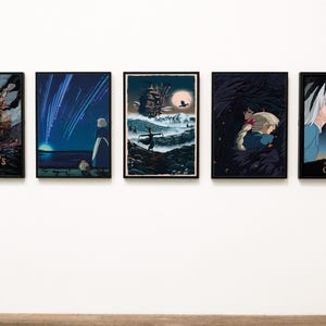 Puede incluir: Cinco impresiones art&iacute;sticas enmarcadas que representan escenas de la pel&iacute;cula de animaci&oacute;n "El castillo ambulante". Las impresiones muestran personajes y paisajes en una paleta de colores oscuros. La primera impresi&oacute;n tiene el texto "HOWL'S MOVING CASTLE".
