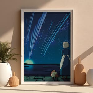 Puede incluir: Una impresi&oacute;n art&iacute;stica enmarcada representa una escena nocturna con una figura mirando un cielo estrellado con estrellas fugaces. La obra de arte est&aacute; en un marco blanco, y la escena se desarrolla sobre un fondo azul y azul oscuro. Hay objetos decorativos delante del marco.