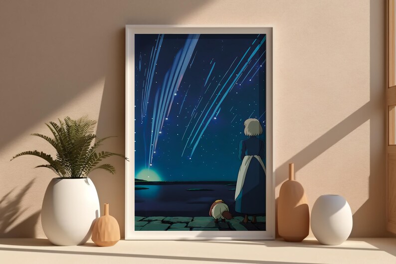 Puede incluir: Una impresi&oacute;n art&iacute;stica enmarcada representa una escena nocturna con una figura mirando un cielo estrellado con estrellas fugaces. La obra de arte est&aacute; en un marco blanco, y la escena se desarrolla sobre un fondo azul y azul oscuro. Hay objetos decorativos delante del marco.
