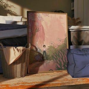 Puede incluir: Una escena de dormitorio con una cama con ropa de cama azul, una obra de arte enmarcada, una cesta de mimbre y dos cojines azules. La obra de arte representa a una persona en un paisaje. La cesta contiene una manta beige. La habitaci&oacute;n est&aacute; iluminada por la luz del sol.