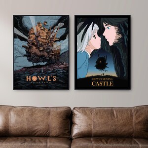 Puede incluir: Dos carteles enmarcados con ilustraciones de "El castillo ambulante". Uno muestra un castillo mec&aacute;nico, el otro representa a dos personajes. Los carteles se exhiben sobre un sof&aacute; de cuero marr&oacute;n.