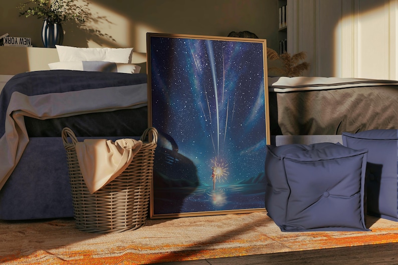 Puede incluir: Una obra de arte enmarcada que representa una escena de noche estrellada con estrellas fugaces y una figura. Una cesta de mimbre con una manta beige est&aacute; cerca de la obra de arte. Un puf azul y una cama con una falda de cama azul tambi&eacute;n est&aacute;n en la habitaci&oacute;n.