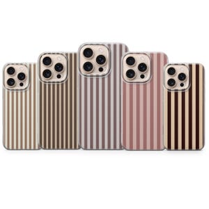 Op de afbeelding: Vijf telefoonhoesjes met verticale streepmotieven in verschillende kleuren, waaronder beige, bruin en mauve. De hoesjes hebben heldere randen en camera-uitsparingen. De hoesjes zijn in een rij gerangschikt en tonen de verschillende kleuropties.